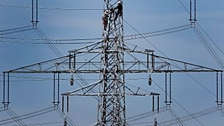 Workers prepare power supply on a high power pylon in Moers, Germany.