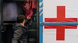 A child is helped off a bus at the registration center in Zaporizhzhia, where the International Committee of the Red Cross has a team waiting to head to Mariupol. 1/4/2022.