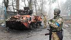 Des soldats ukrainiens examinent un véhicule militaire détruit à Irpin, près de Kyiv, en Ukraine, vendredi 1er avril 2022.