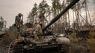 Ukrainische Soldaten posieren auf einem russischen Panzer im Großraum Kiew, 31.03.2022