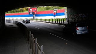 Un coche pasa junto a un cartel publicitario preelectoral que muestra a Ivica Dacic, líder del Partido Socialista de Serbia, en Belgrado