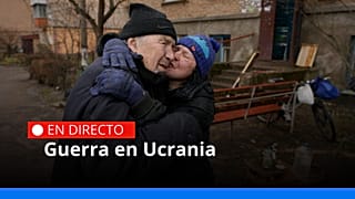 Una pareja cocina en frente de un edificio de apartamentos que no tiene electricidad, agua o gas en Bucha
