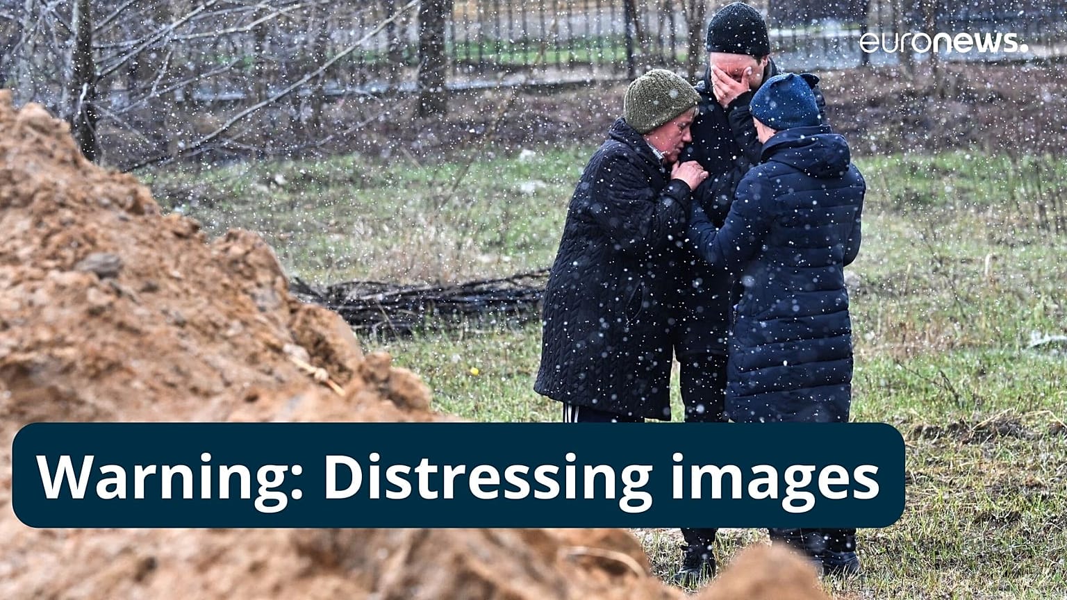 People cry as they gather close to a mass grave in the town of Bucha, just northwest of the Ukrainian capital Kyiv. April 3, 2022