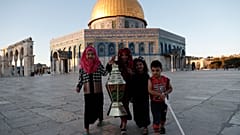 أطفال يتصورون إلى جانب فانوس رمضان مقابل المسجد الأقصى في القدس