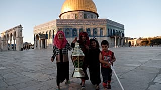 أطفال يتصورون إلى جانب فانوس رمضان مقابل المسجد الأقصى في القدس