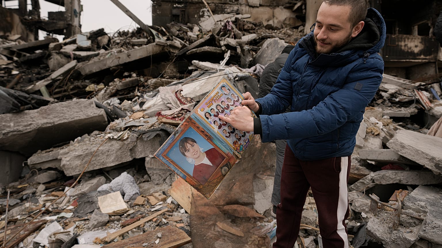 Ein Mann zieht ein altes Schulheft mit Klassenfotos aus dem Schutt seines zerstörten Hauses in Borodjanka nahe Kiew. 