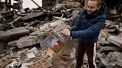 Ein Mann zieht ein altes Schulheft mit Klassenfotos aus dem Schutt seines zerstörten Hauses in Borodjanka nahe Kiew. 