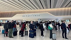 Passengers queue for security screening in the departures area of Terminal 2 at Manchester Airport in Manchester, Britain.