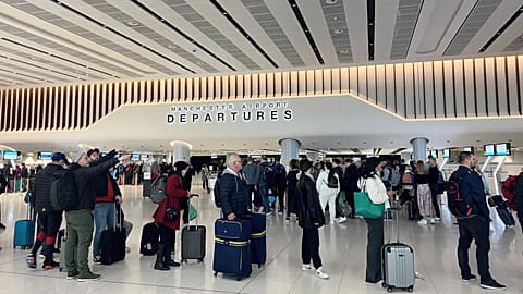 Passengers queue for security screening in the departures area of Terminal 2 at Manchester Airport in Manchester, Britain.