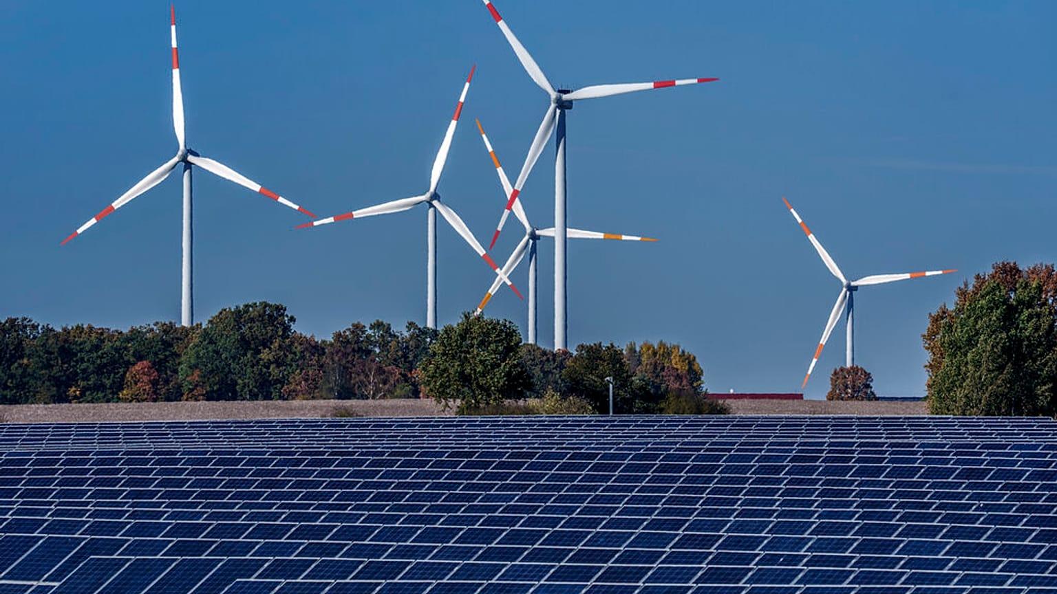 Des éoliennes tournent derrière un parc solaire à Rapshagen, en Allemagne, le 28 octobre 2021.