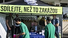 Members of the Vietnamese community queue up as Czech Prime Minister Andrej Babis (C) signs his book "Do share before they ban it!" during the election campaign in 2021.