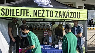 Members of the Vietnamese community queue up as Czech Prime Minister Andrej Babis (C) signs his book "Do share before they ban it!" during the election campaign in 2021.