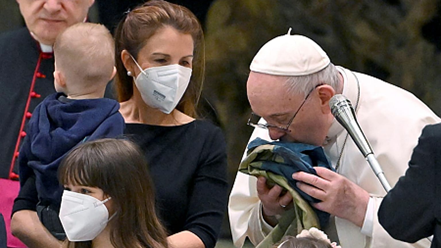 Pope Francis kisses a Ukrainian flag