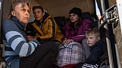 From left to right, Oksana Gavrielutca 41, sits at the back of a bus with her children Oleg 18, Diana 17 and Vlad 5 after they flee from Snigiriovka village, in Mikolaiv distr