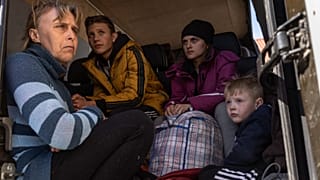 From left to right, Oksana Gavrielutca 41, sits at the back of a bus with her children Oleg 18, Diana 17 and Vlad 5 after they flee from Snigiriovka village, in Mikolaiv distr