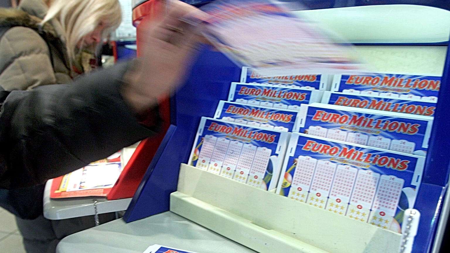  A customer picks up a Lotto ticket in a Paris shop in 2006. 