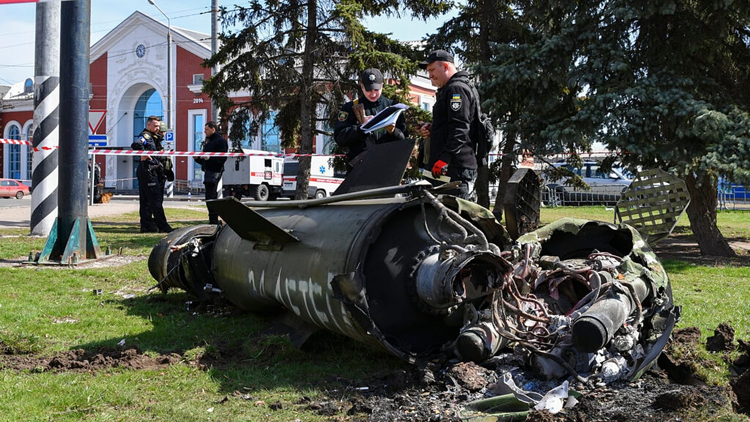 Des militaires ukrainiens à côté d'un fragment de missile Tochka-U portant l'inscription en russe "Pour les enfants", après un bombardement russe à la gare de Kramatorsk.