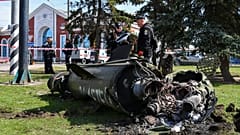 Des militaires ukrainiens à côté d'un fragment de missile Tochka-U portant l'inscription en russe "Pour les enfants", après un bombardement russe à la gare de Kramatorsk.