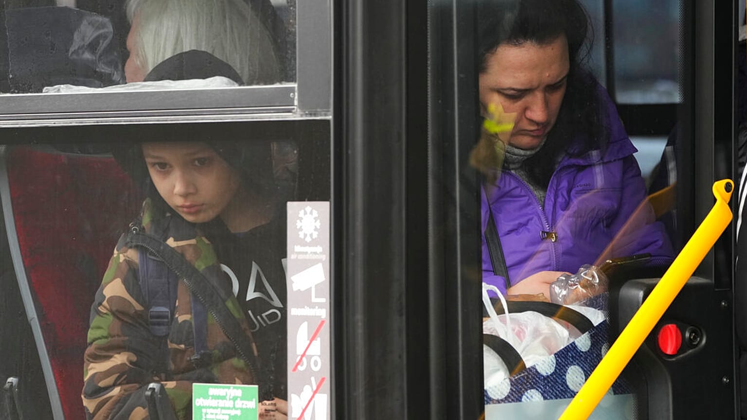 Una mujer refugiada con un niño se sienta en un autobús en la estación central de trenes de Varsovia, Polonia, el jueves 7 de abril de 2022.
