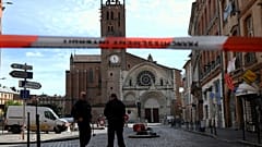 Security personnel gather at the entrance of Saint Etienne Cathedral in Toulouse.