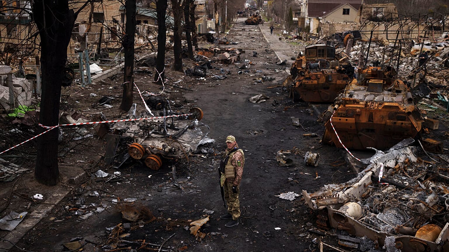 Ein ukrainischer Soldat steht inmitten zerstörter russischer Panzer in Butscha, am Stadtrand von Kiew, Ukraine, 6. April 2022.