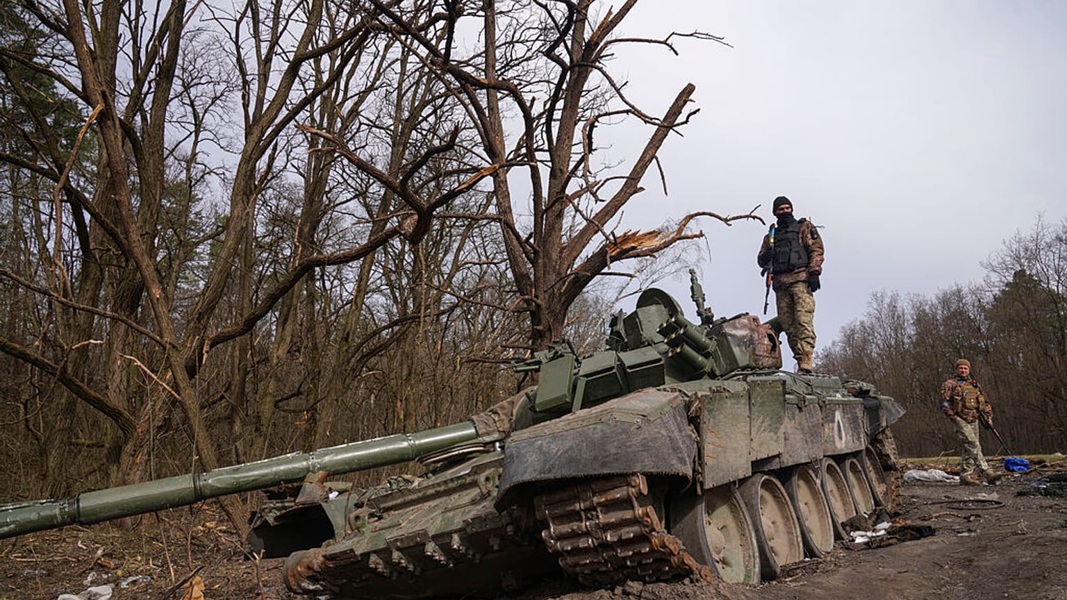 Un soldat ukrainien se tient au sommet d'un char russe détruit dans la région de Tchernihiv, en Ukraine, le vendredi 8 avril 2022. 