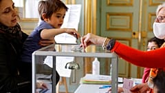 Mutter mit Sohn bei der Stimmabgabe in Frankreich