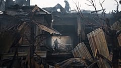 Firefighters work to extinguish a fire at a house after a Russian attack in Kharkiv, Ukraine, Monday, April 11, 2022.
