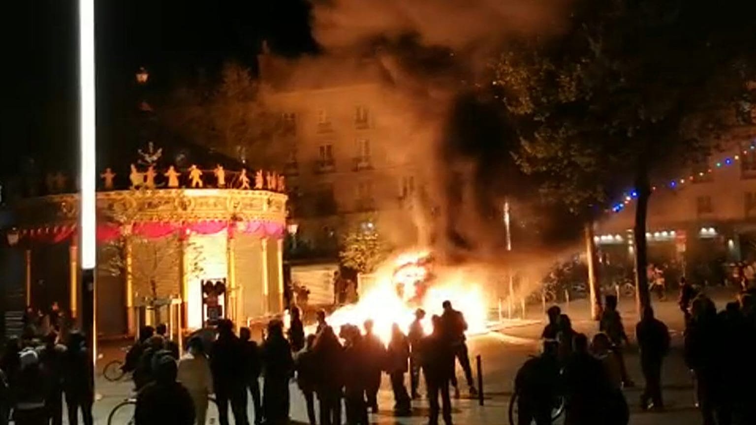 Demonstrators gathered around a blaze lit with construction equipment