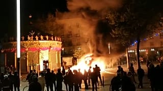 Demonstrators gathered around a blaze lit with construction equipment
