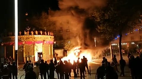 Demonstrators gathered around a blaze lit with construction equipment