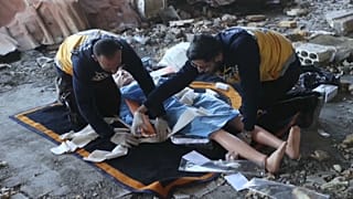 Zwei syrische Rettungskräfte zeigen die Versorgung von Kriegsopfern