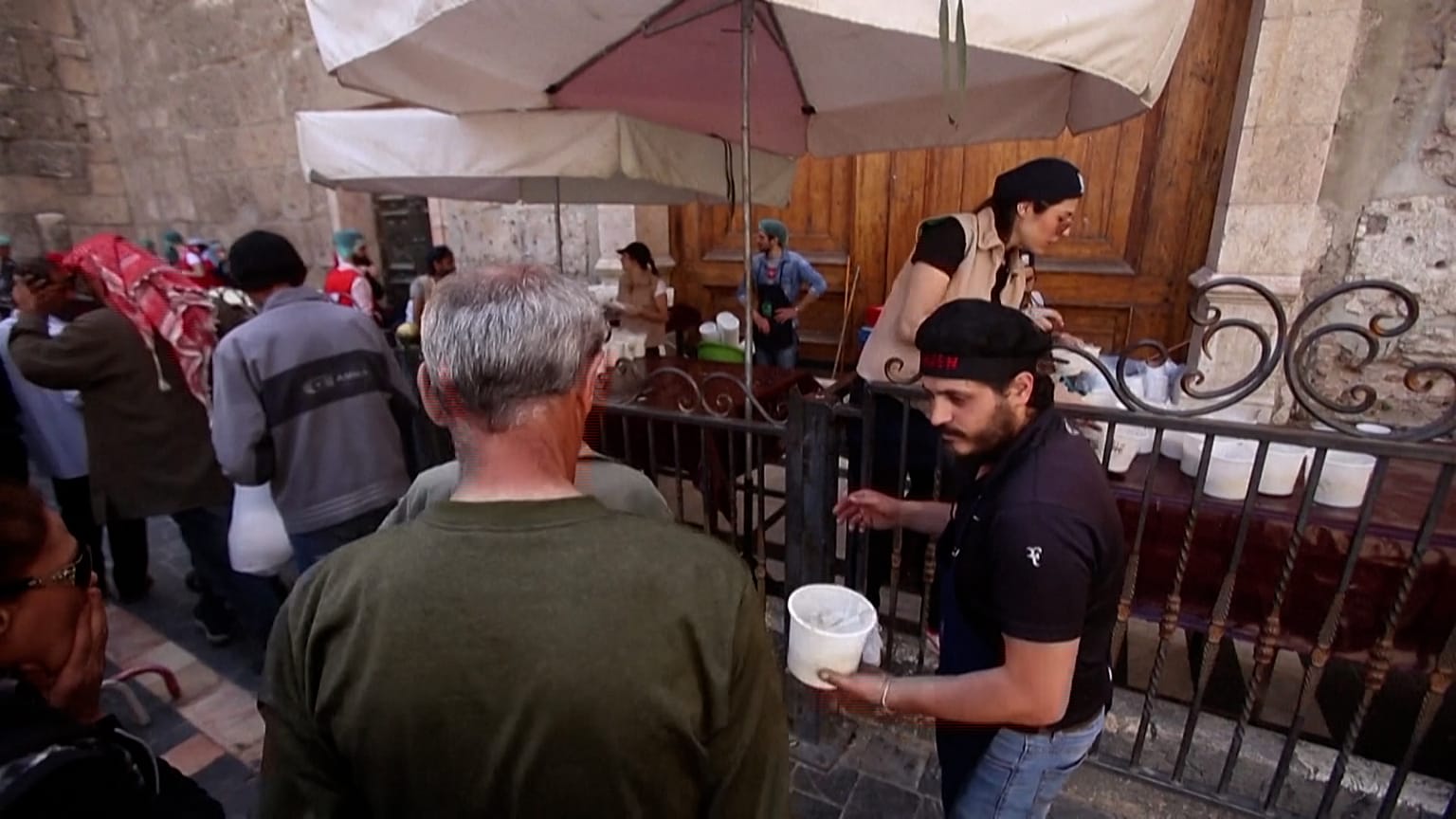 Syrians queue to receive free Iftar meals being distributed by a local charity in the capital of Damascus.