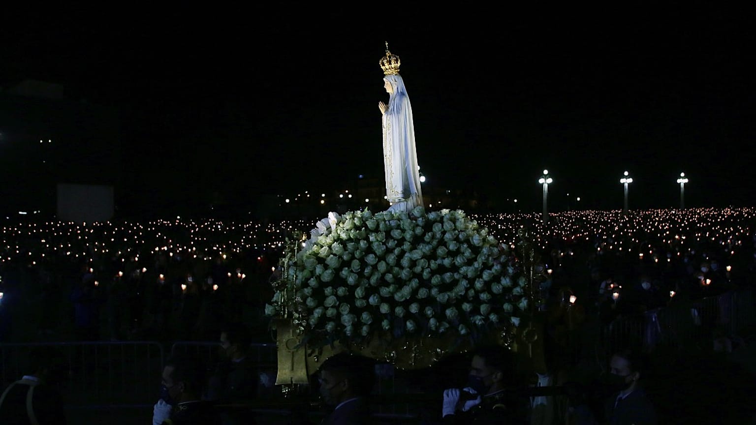 The statue of Our Lady of Fatima is carried past worshippers holding candles in a procession at the Catholic shrine in Fatima, Portugal, Wednesday, May 12, 2021.