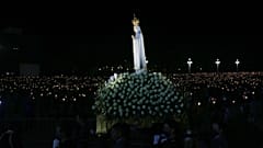 The statue of Our Lady of Fatima is carried past worshippers holding candles in a procession at the Catholic shrine in Fatima, Portugal, Wednesday, May 12, 2021.