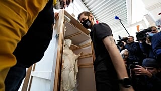 Сотрудники Эрмитажа разгружают ящики с экспонатами, вернувшимися с выставки "Гран Тур. Мечта об Италии от Венеции до Помпей".