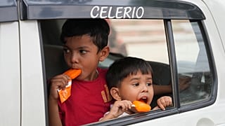 Unos niños comen un helado sentados en un coche en Prayagraj, en el norteño estado indio de Uttar Pradesh, 13/4/2022. 