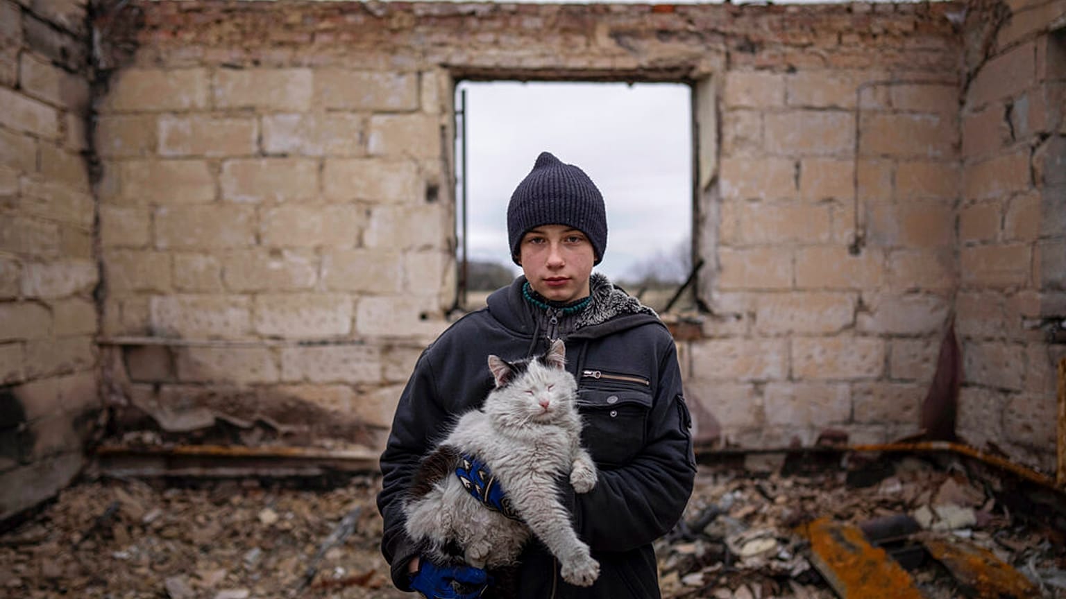 Danyk Rak, 12, holds a cat standing on the debris of his house destroyed by Russian forces' shelling in the outskirts of Chernihiv, Ukraine, Wednesday, April 13, 2022.