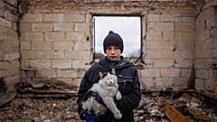 Danyk Rak, 12, holds a cat standing on the debris of his house destroyed by Russian forces' shelling in the outskirts of Chernihiv, Ukraine, Wednesday, April 13, 2022.