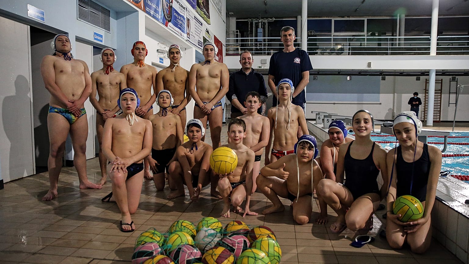 Treinador ucraniano Roman Fomichenko com o presidente do clube, Daniel Galvoeira, e atletas da equipa sub-12 de pólo aquático do Aminata Évora Clube de Natação