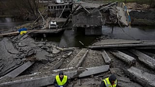 Engineers inspect the state of destruction of the bridge that connects Kyiv with Irpin