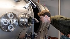 Image shows CEO and Co-founder of First Light Fusion, Dr. Nick Hawker inspecting machinery at his factory that aim to cheaply create green energy via nuclear fusion.