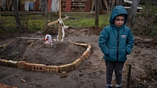 Vlad, 6, steht neben dem Grab seiner Mutter in einer Kiewer Vorstadt. Die Familie hielt sich einen Monat in einem Bunker vor den russischen Truppen versteckt. 4. April 2022