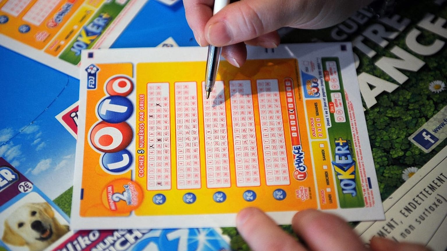 A French gambler fills in a lottery ticket of Super Loto.