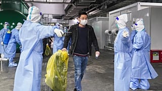 Pacientes de COVID-19 salen de un hospital improvisado en el Centro Nacional de Exposiciones y Convenciones de Shanghai, el jueves 14 de abril de 2022