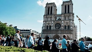 The faithful attend the Way of the Cross ceremony as part of the Holy Easter celebration, on the forecourt of Notre Dame Cathedral, in Paris, Friday, April 15, 2022