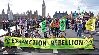 Demonstrators take part in an Extinction Rebellion protest on Westminster Bridge in London, Friday, April 15, 2022. 