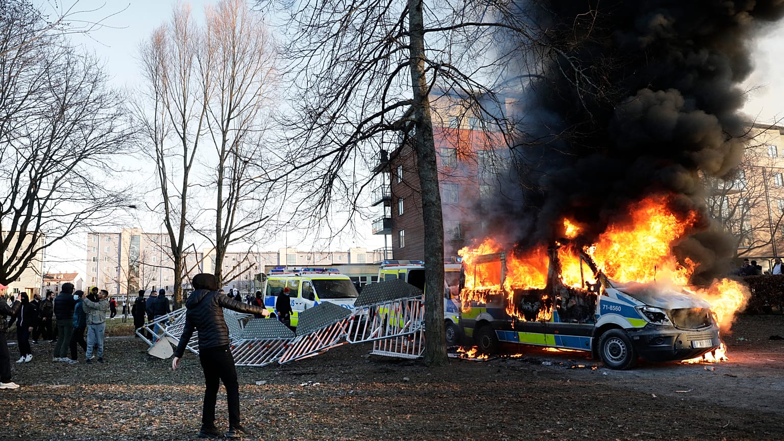 Police vans are on fire as counter-protesters react during a counter-protest in the park Sveaparken in Orebro, south-centre Sweden on April 15, 2022.