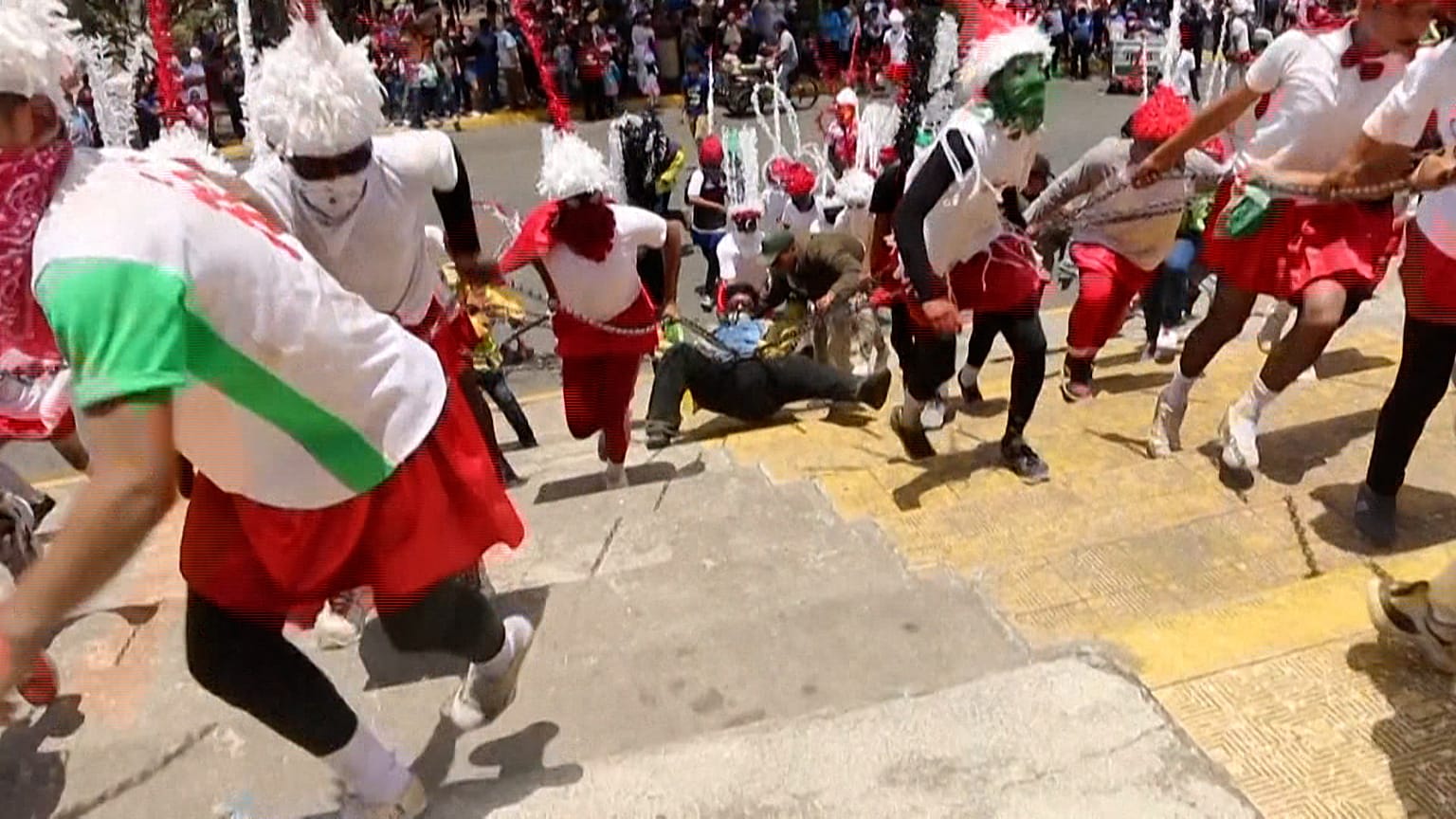 People drag a man, portraying Judas, with chains during the procession of 'Los Encadenados' (The Chained) on Good Friday