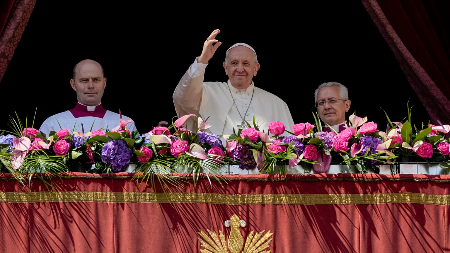 Pope Francis, centre, waves to the crowd after the traditional 'Urbi et Orbi' blessing after Easter Sunday mass in St. Peter's Square at the Vatican, Sunday, April 17, 2022.